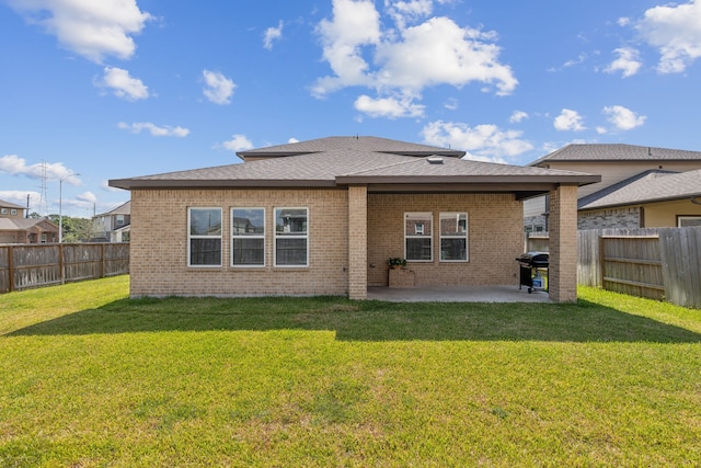 rear view of property featuring a yard and a patio area