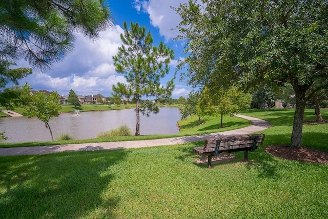 surrounding community with a water view and a yard