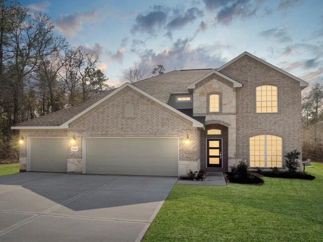 view of front of house with a garage and a yard