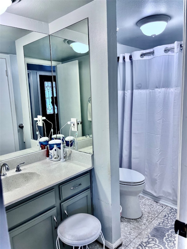 bathroom featuring toilet, tile patterned flooring, vanity, and curtained shower