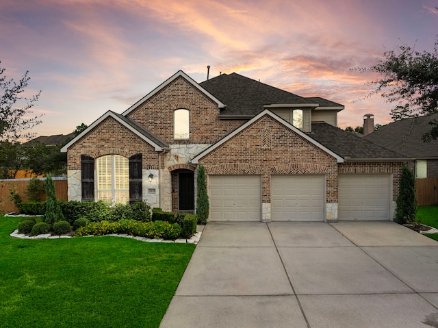 front of property with a yard and a garage