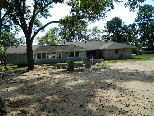 rear view of property featuring a sunroom and central AC unit