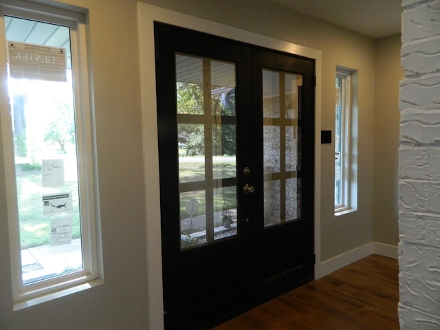 entryway with plenty of natural light, dark wood-type flooring, french doors, and baseboards