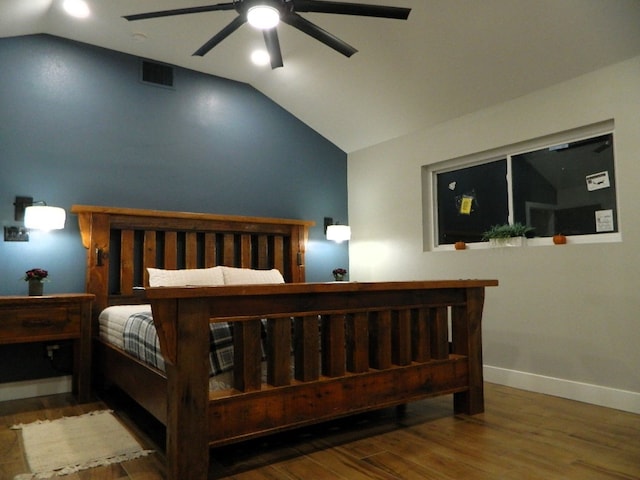 bedroom with lofted ceiling, wood finished floors, visible vents, and baseboards