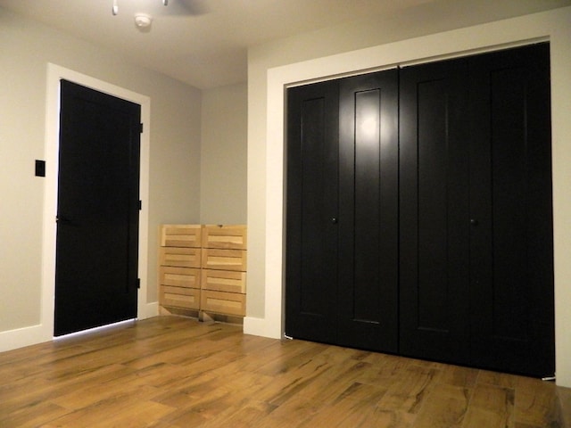 unfurnished bedroom with a closet and wood finished floors