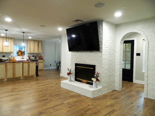 living room with recessed lighting, a fireplace, and wood finished floors