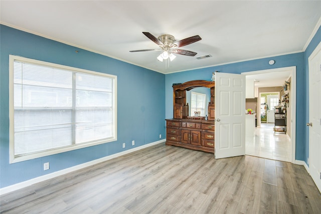 unfurnished bedroom with ceiling fan, crown molding, and light wood-type flooring