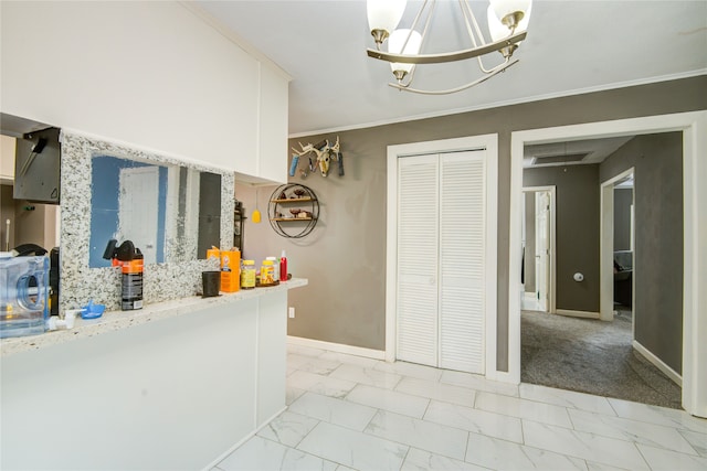 kitchen featuring light carpet, white cabinets, ornamental molding, light stone countertops, and a chandelier