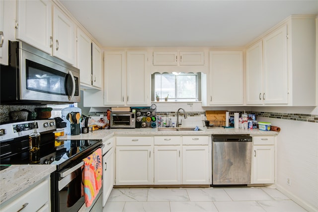 kitchen featuring white cabinetry, sink, and appliances with stainless steel finishes