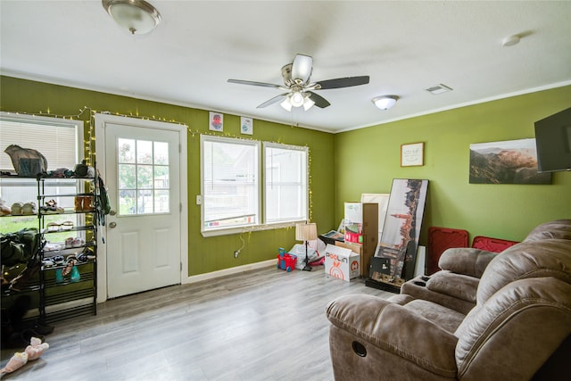 recreation room with light hardwood / wood-style floors, ceiling fan, and ornamental molding