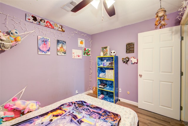 bedroom with dark hardwood / wood-style floors and ceiling fan