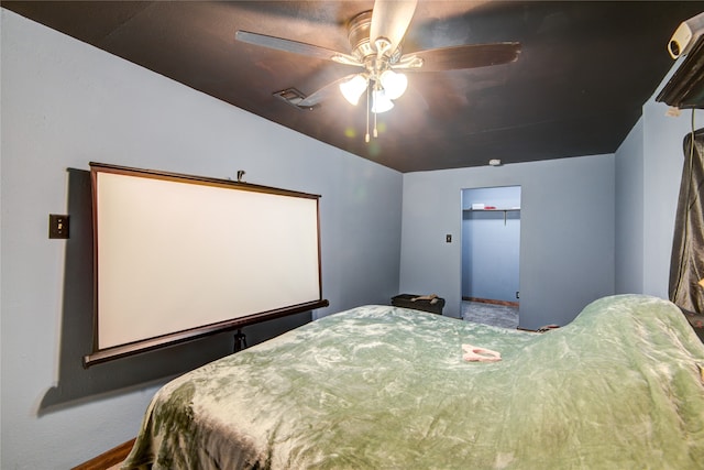 bedroom with a walk in closet, a closet, and ceiling fan