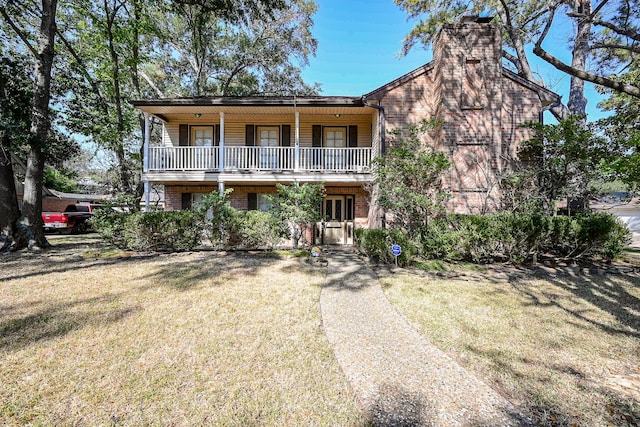 view of front facade featuring a balcony and a front lawn