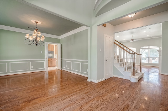 unfurnished room with hardwood / wood-style floors, ceiling fan with notable chandelier, and ornamental molding