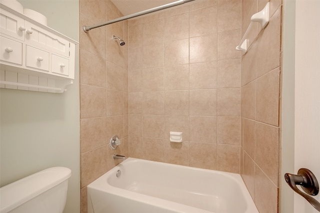 bathroom featuring tiled shower / bath combo and toilet