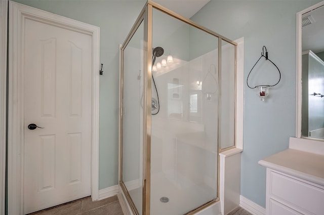 bathroom with tile patterned floors, vanity, and walk in shower