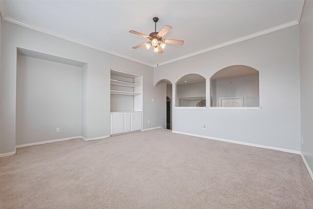 20807 Twisted Leaf Dr, Cypress, TX 77433 - carpeted empty room with a ceiling fan, built in shelves, crown molding, baseboards, and arched walkways