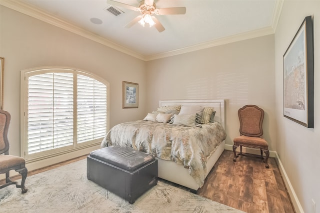 bedroom with wood-type flooring, ornamental molding, and ceiling fan