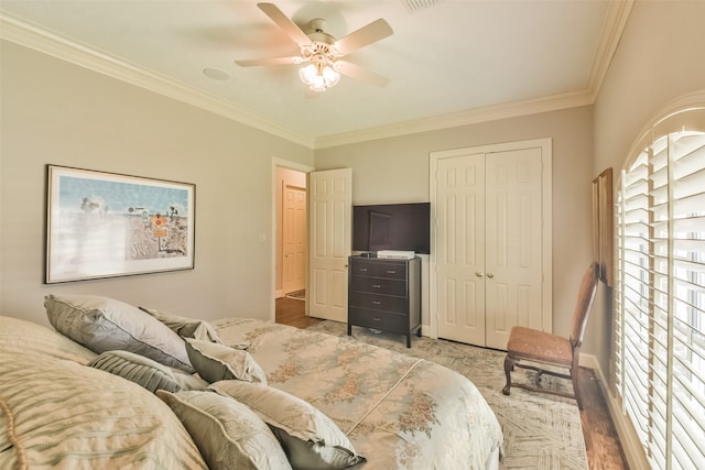 bedroom featuring ornamental molding, multiple windows, hardwood / wood-style flooring, and ceiling fan