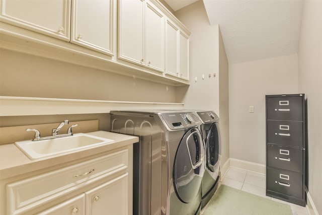 laundry area featuring cabinets, a textured ceiling, sink, light tile patterned floors, and washing machine and dryer