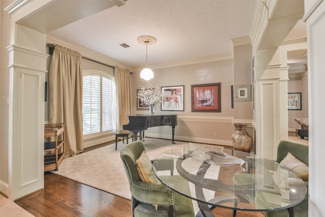 dining space featuring ornamental molding, decorative columns, and dark hardwood / wood-style flooring