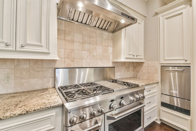 kitchen with white cabinetry, stainless steel stove, exhaust hood, dark hardwood / wood-style floors, and light stone countertops