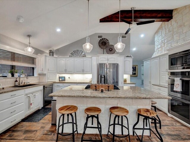 kitchen with stainless steel appliances, dark wood-type flooring, and a center island