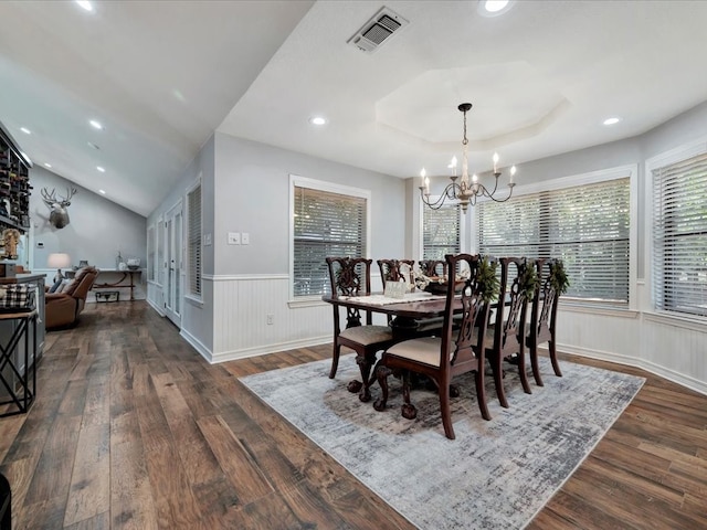 dining room with a notable chandelier, vaulted ceiling, and dark wood-type flooring