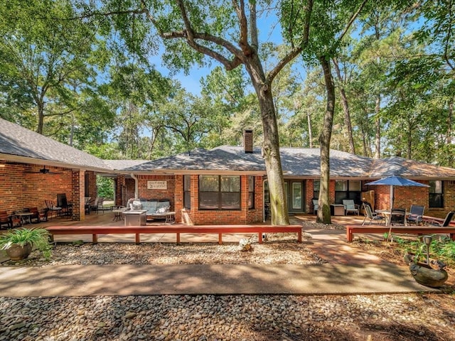 rear view of house featuring a deck and outdoor lounge area