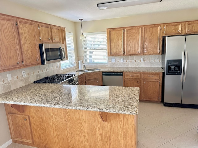 kitchen featuring backsplash, kitchen peninsula, appliances with stainless steel finishes, and sink