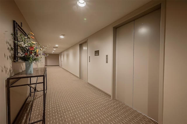 hall featuring light carpet and elevator