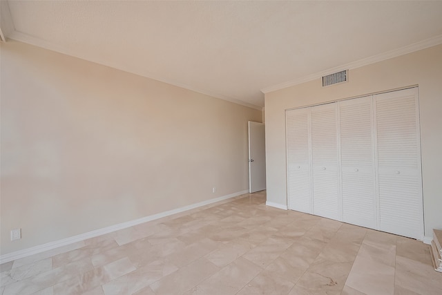 unfurnished bedroom with crown molding and a closet