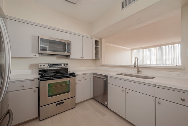 kitchen with white cabinets, appliances with stainless steel finishes, and sink