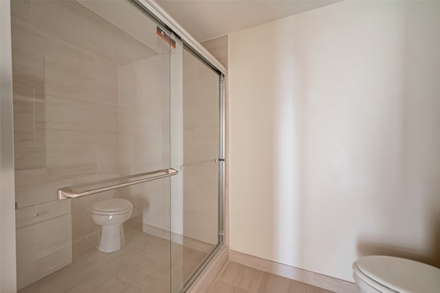 bathroom featuring walk in shower, tile walls, and toilet