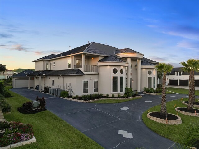 view of front of home featuring a balcony and a yard