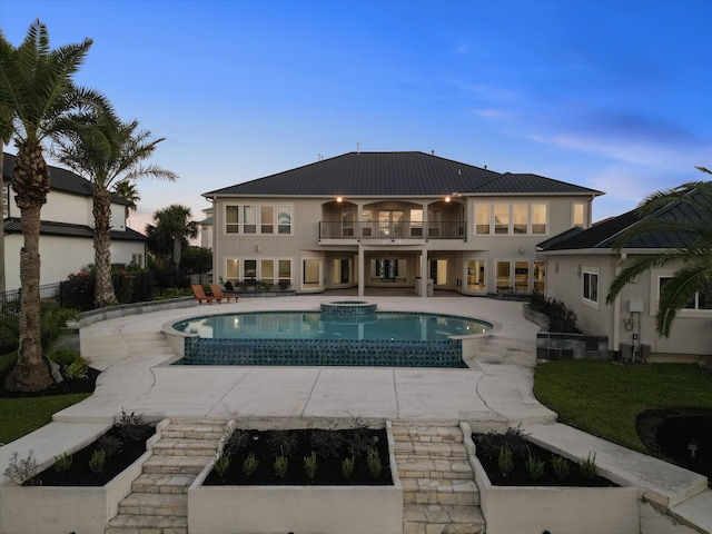 pool at dusk with a patio area