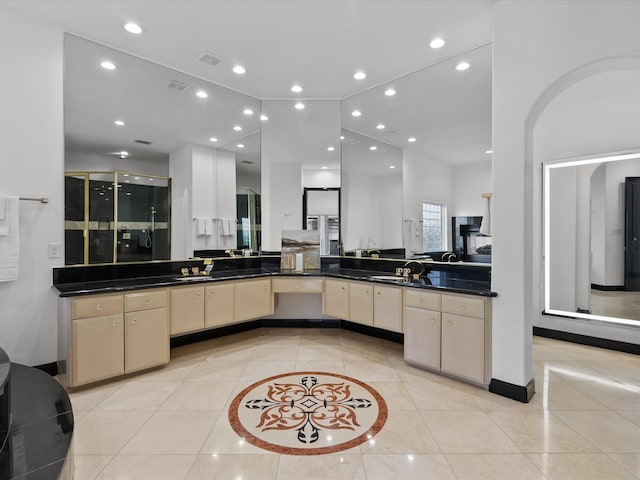 kitchen featuring kitchen peninsula, sink, light tile patterned floors, and cream cabinetry