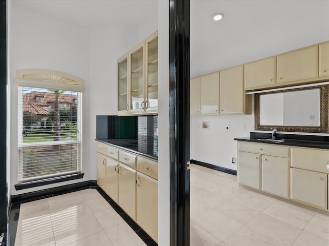 kitchen with cream cabinetry, light tile patterned flooring, and sink