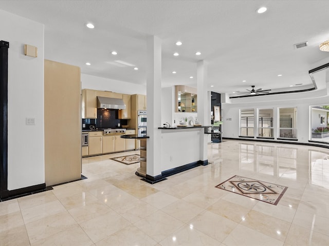 kitchen with ceiling fan, extractor fan, appliances with stainless steel finishes, a breakfast bar area, and decorative backsplash