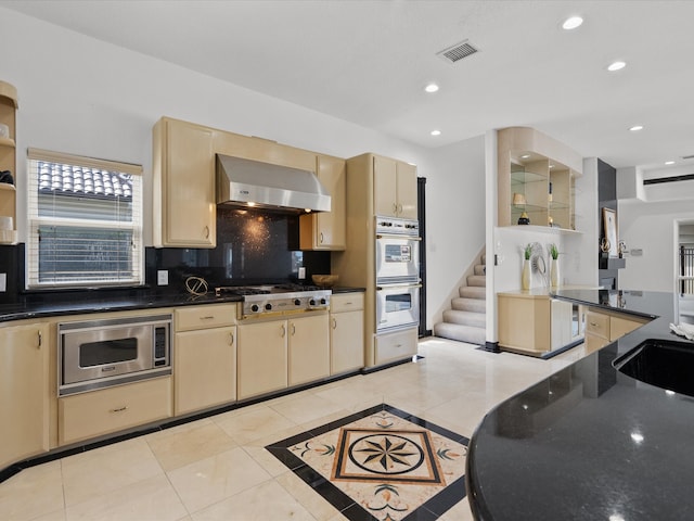 kitchen featuring light tile patterned floors, extractor fan, stainless steel appliances, and tasteful backsplash