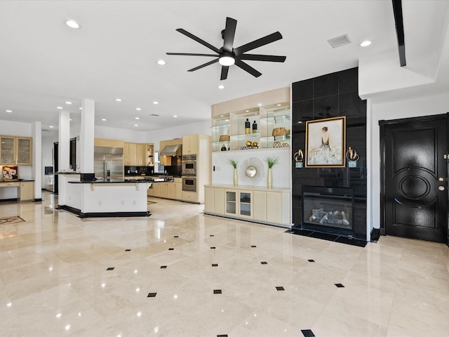 living room featuring ceiling fan and a tile fireplace