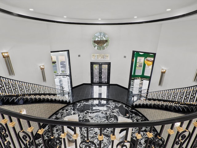 staircase with a high ceiling and french doors