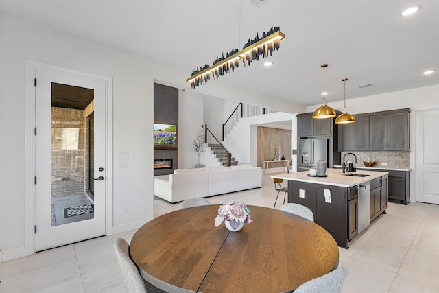 11915 Parsifal Creek Rd, Humble, TX 77346 - dining area featuring recessed lighting, stairway, light tile patterned floors, a glass covered fireplace, and visible vents