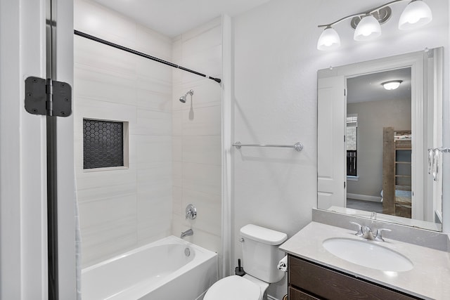 full bathroom featuring tiled shower / bath combo, toilet, and vanity