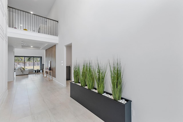 11915 Parsifal Creek Rd, Humble, TX 77346 - corridor with light tile patterned floors, a towering ceiling, and baseboards