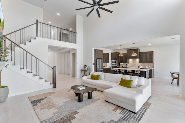 11915 Parsifal Creek Rd, Humble, TX 77346 - living room featuring a towering ceiling, light tile patterned flooring, ceiling fan, and stairway