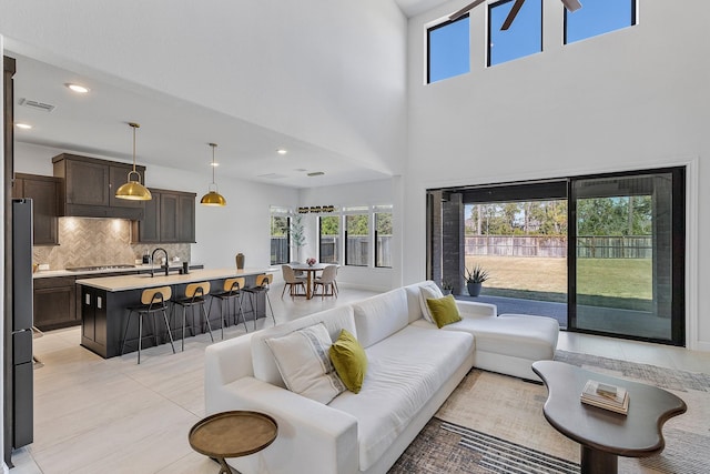 11915 Parsifal Creek Rd, Humble, TX 77346 - living area featuring a towering ceiling, light tile patterned flooring, visible vents, and a wealth of natural light