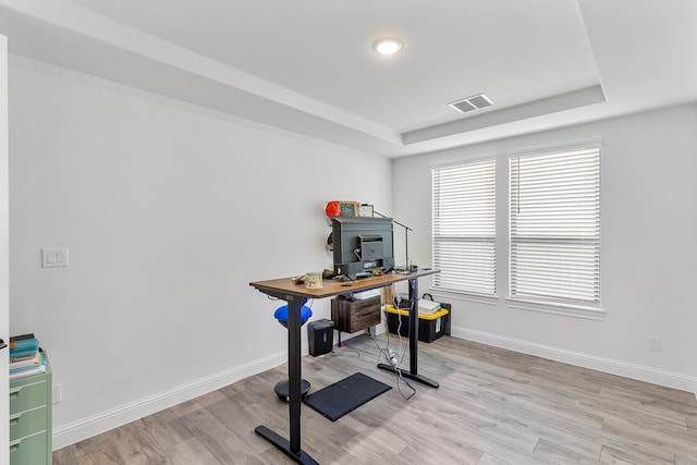 office with a raised ceiling and light hardwood / wood-style flooring