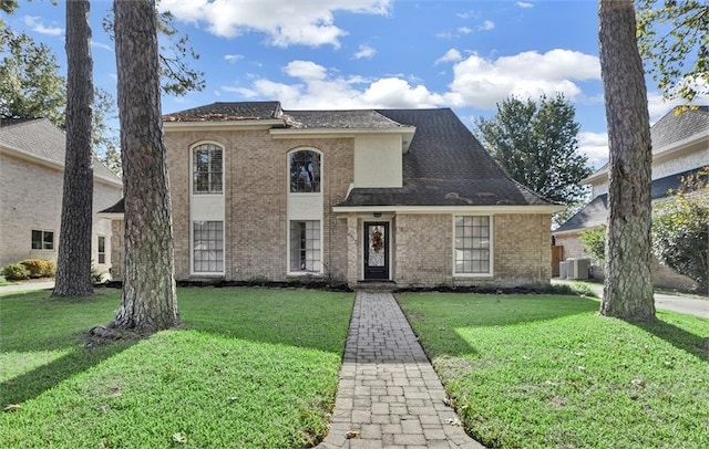 view of front of house with a front lawn and central air condition unit