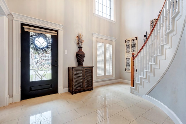 entrance foyer with a high ceiling and light tile patterned floors